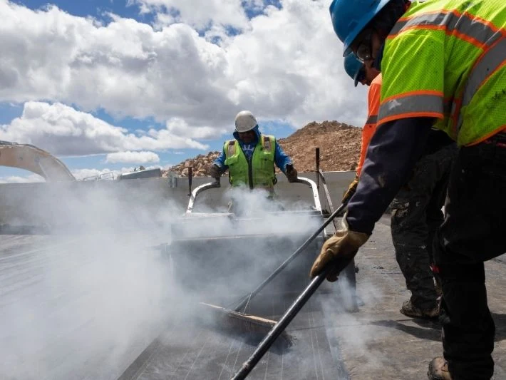 Superior Roofing crew applying asphalt during built-up roof installation on Pikes Peak