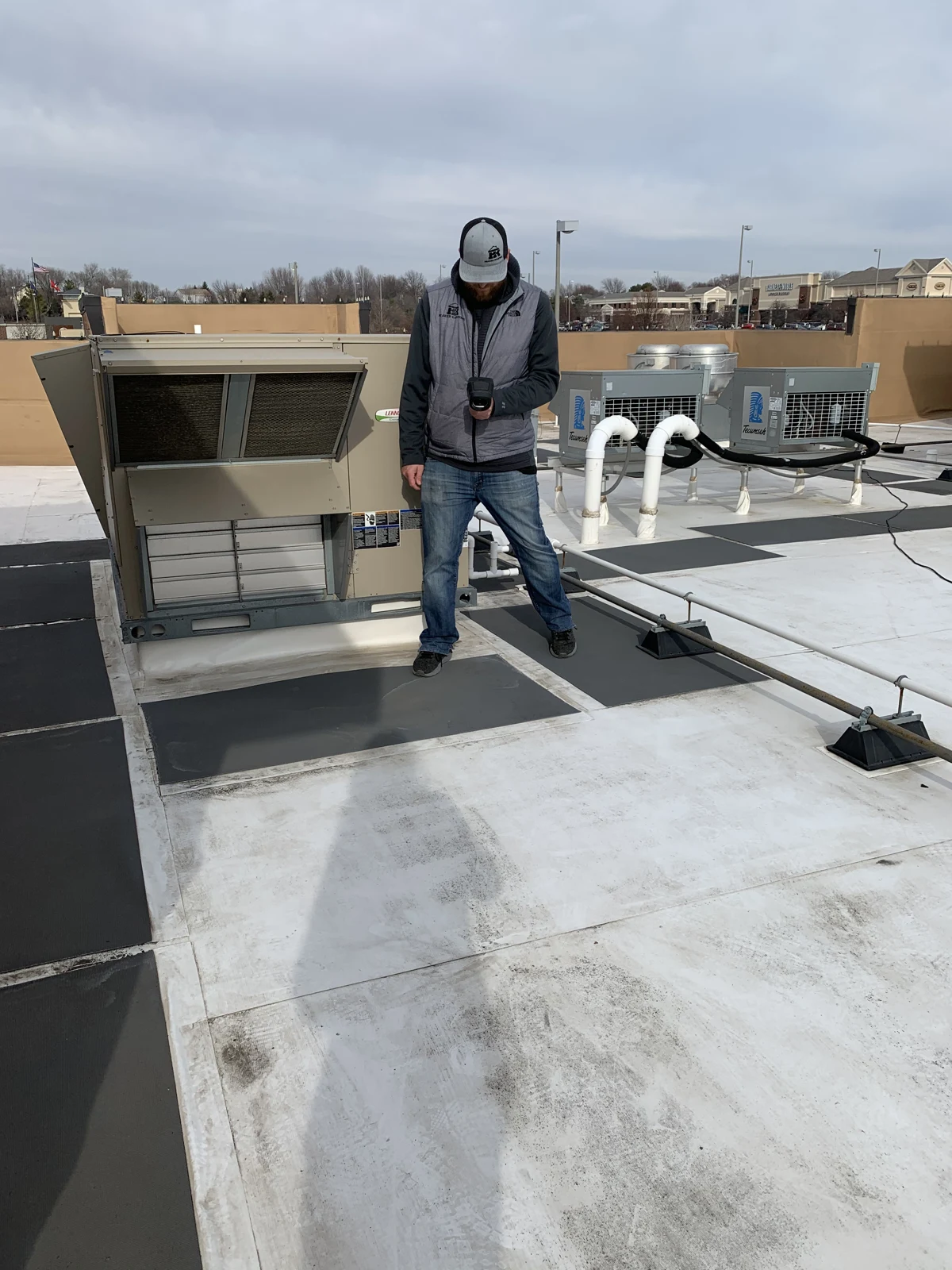 A Peaked team member inspecting a commercial rooftop.